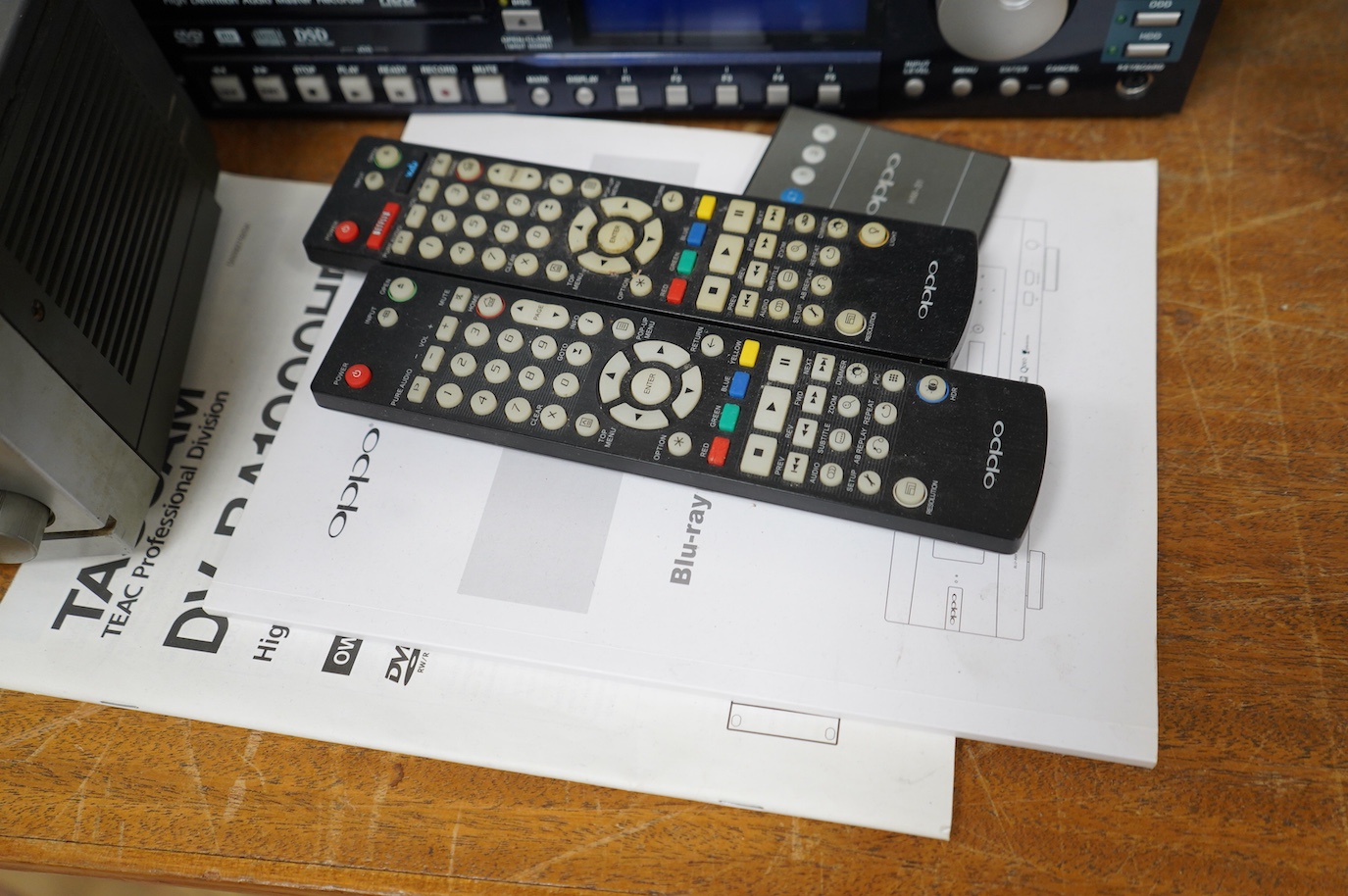 Three Blu-ray/DVD players including; an OPPO BDP-105EU Blu-ray player with user manual and remote control, a Pioneer BDP-LX91 Blu-ray player with remote control, and a Tascam DV-RA1000HD DVD player with owners manual, bu